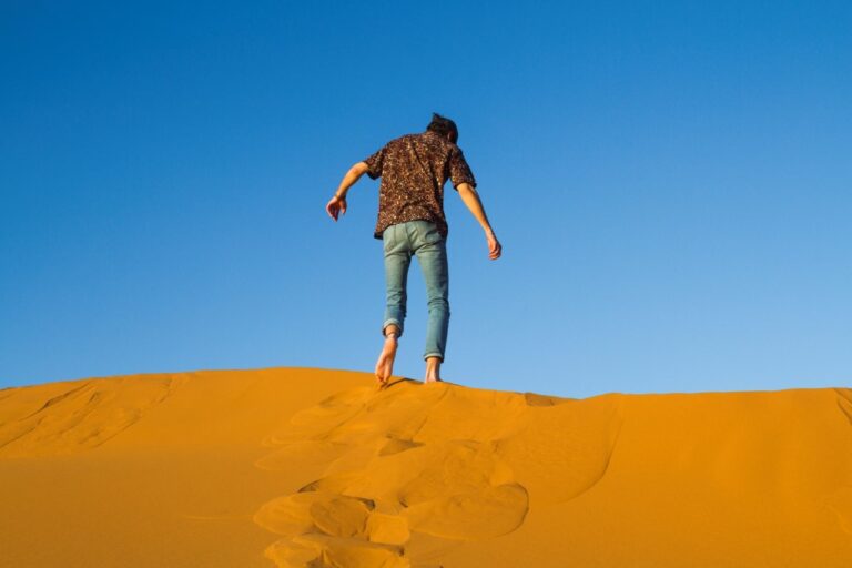 man-walking-top-dune-desert